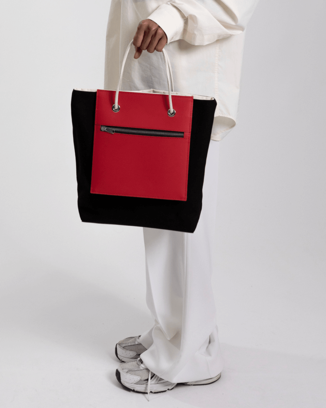 Un Sac à main noir et rouge de fourre-tout réversible et de moyenne capacité