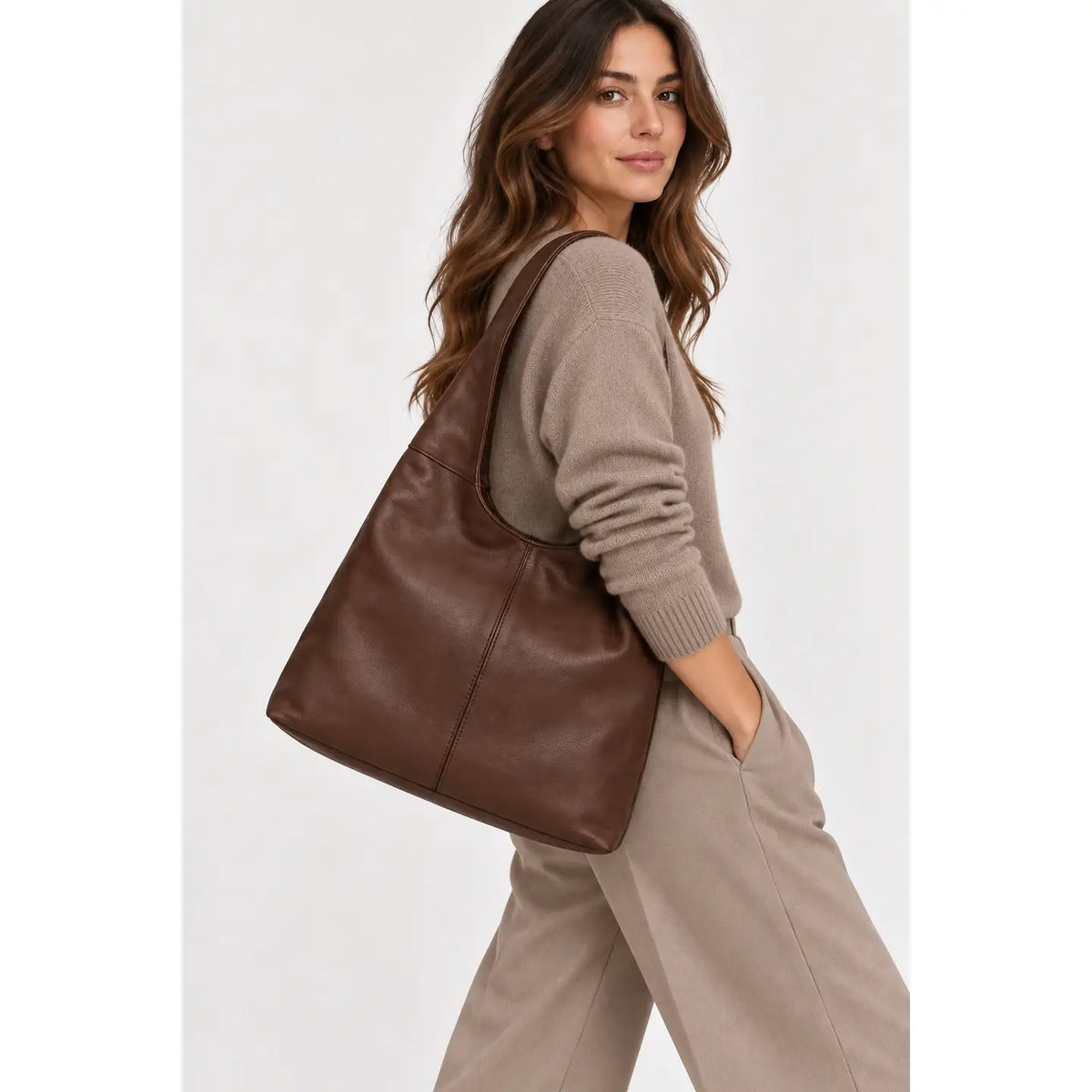 Sac à main marron à large anse porté à l’épaule par une femme, vue de profil