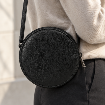 Pochette Almita Grande en cuir noir portée à l’épaule 