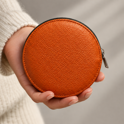 Pochette Almita Grande en cuir orange tenue à la main