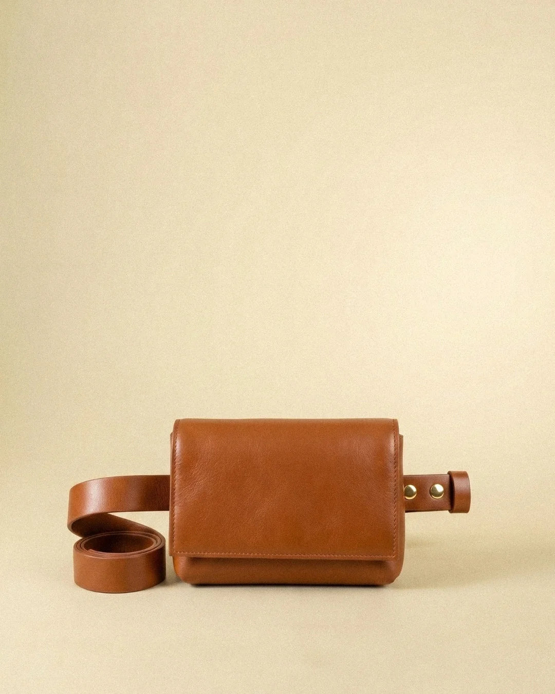 Sac ceinture Fernandita en cuir orange, vu de face avec sa ceinture enroulée, Bmassy.