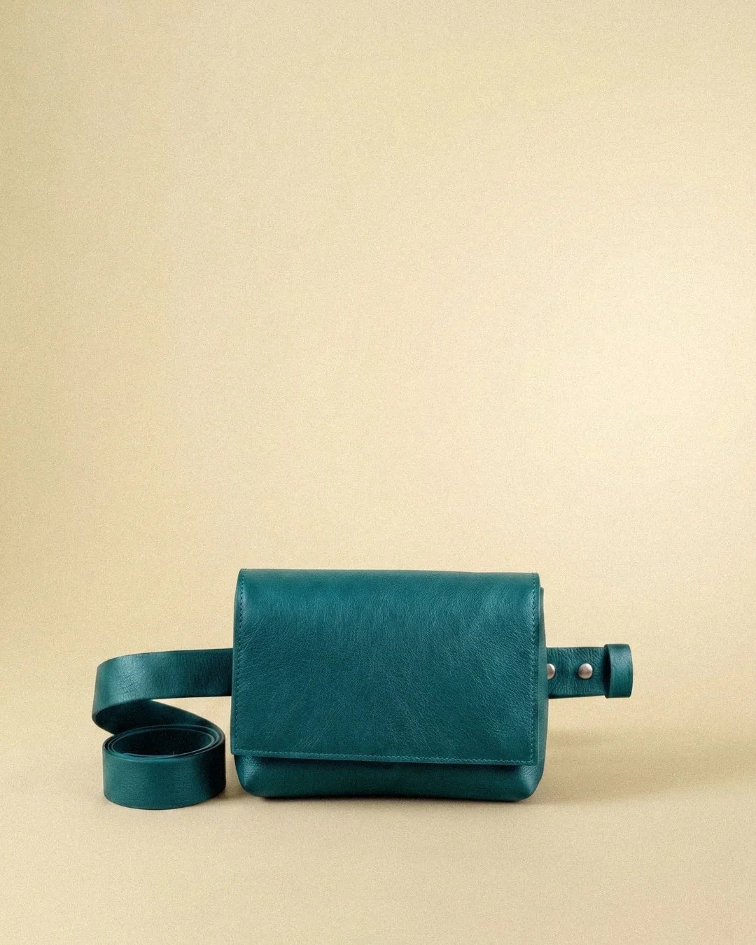 Sac ceinture Fernandita en cuir turquoise, vu de face avec sa ceinture enroulée, Bmassy.