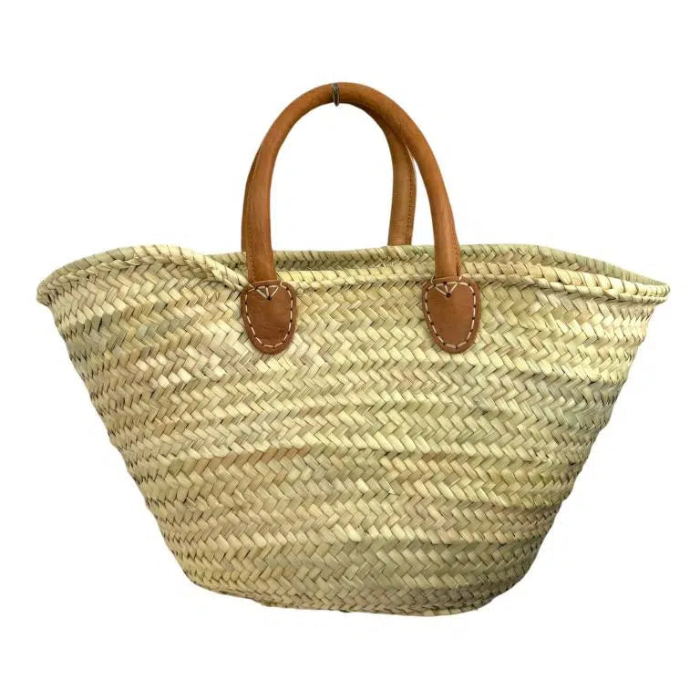 Grand panier cabas en raphia beige naturel tressé, vu de face avec anses courtes en cuir camel sur fond blanc