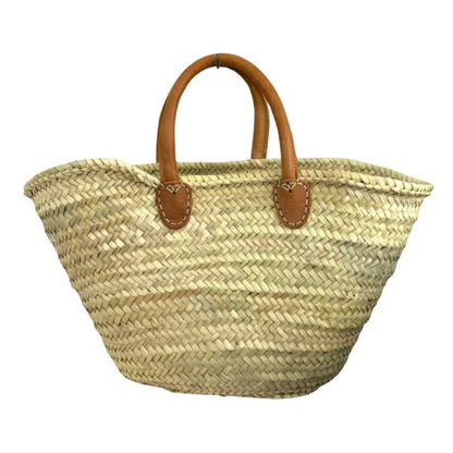Grand panier cabas en raphia beige naturel tressé, vu de face avec anses courtes en cuir camel sur fond blanc