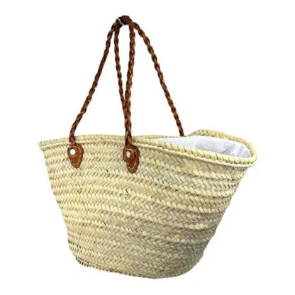 Grand panier de plage beige naturel, de forme évasée, avec poignées en cuir marron tressé. 