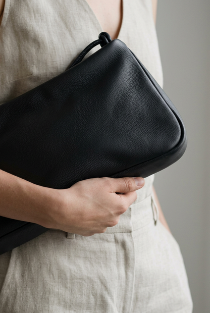 Gros plan du sac MariLoli en cuir noir tenu contre soi