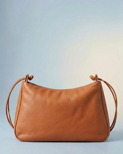 Sac MariLoli en cuir orange porté à l’épaule, vue de profil