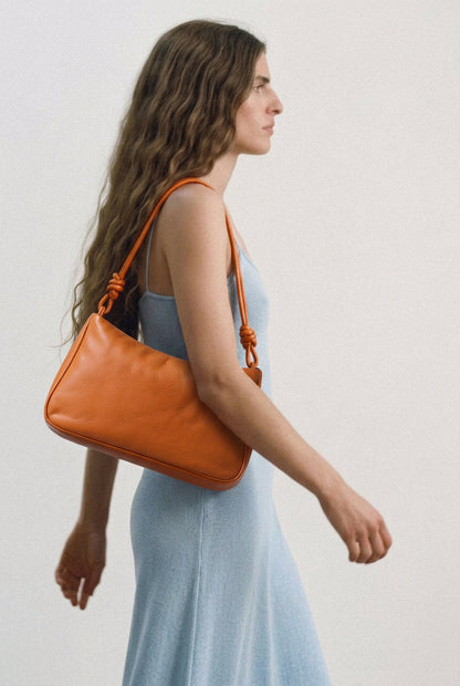 Sac MariLoli en cuir orange porté à l’épaule, vue de profil