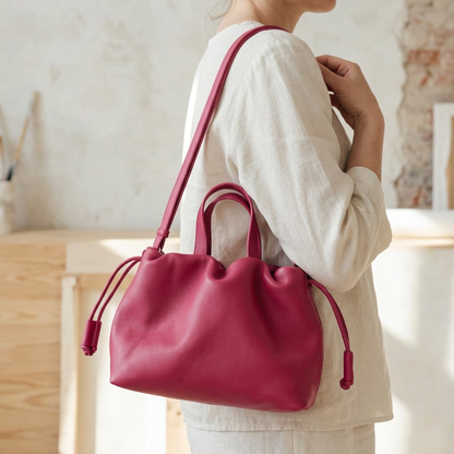 Petit sac à main Angelines en cuir rose framboise porté à l’épaule avec sa sangle, Bmassy.