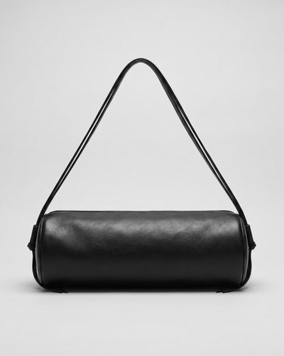 Sac Alma en cuir noir de forme cylindrique, présenté avec ses cordons ajustés pour un porté épaule