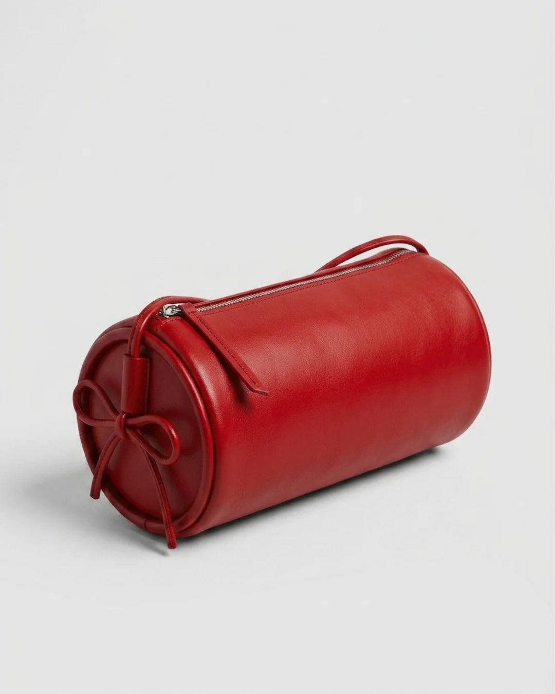 Sac à main Alma rouge en cuir végétal, forme cylindrique artisanale, porté en bandoulière