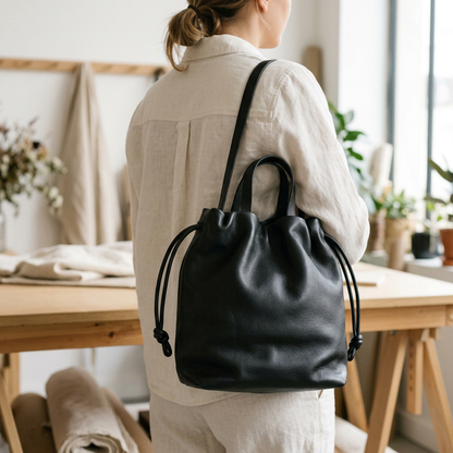 Sac à main Angela Medium en cuir noir porté à l’épaule sur une femme vue de dos, Bmassy.