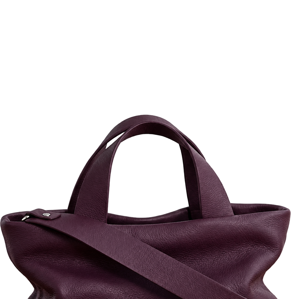 Gros plan sur les poignées et l’attache de bandoulière du sac Juanita en cuir aubergine, Bmassy.