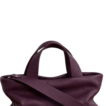 Gros plan sur les poignées et l’attache de bandoulière du sac Juanita en cuir aubergine, Bmassy.