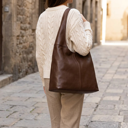 Sac à main marron à large anse porté à l’épaule par une femme vue de dos