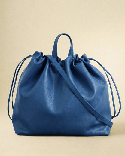 Sac à main maxi Dona Angela en cuir bleu vu de face avec ses poignées, sa bandoulière et ses cordons de serrage, Bmassy.