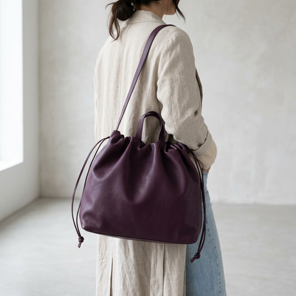 Sac à main maxi Dona Angela en cuir bordeaux porté à l’épaule sur une femme vue de dos, Bmassy.