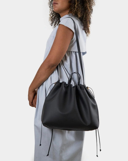 Sac à main maxi Dona Angela en cuir noir porté à l’épaule avec sa bandoulière, en vue rapprochée, Bmassy.