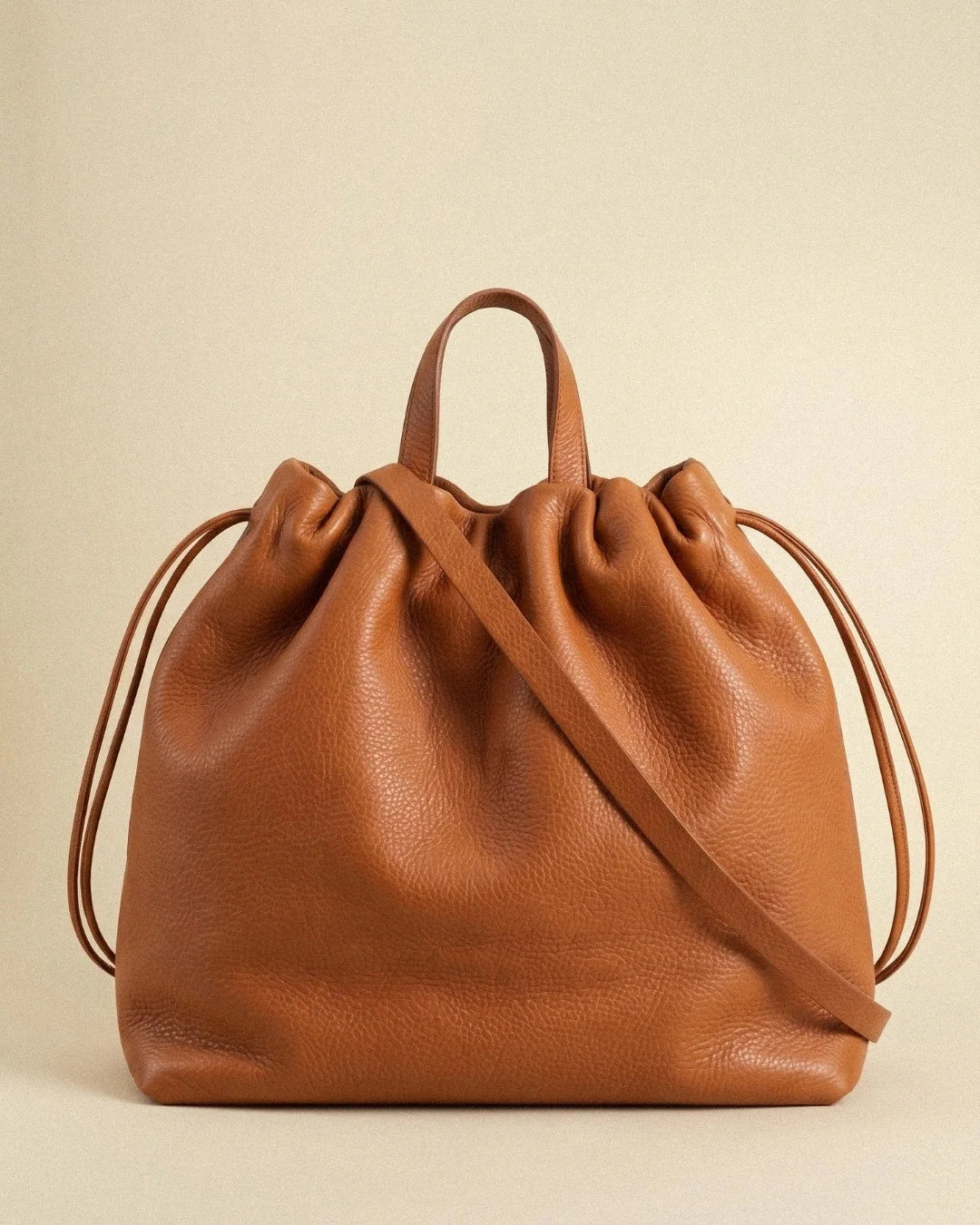 Sac à main maxi Dona Angela en cuir orange vu de face avec ses poignées, sa bandoulière et ses cordons de serrage, Bmassy.
