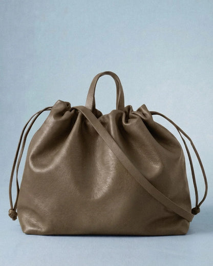 Sac à main maxi Dona Angela en cuir taupe vu de face avec ses poignées, sa bandoulière et ses cordons de serrage, Bmassy.