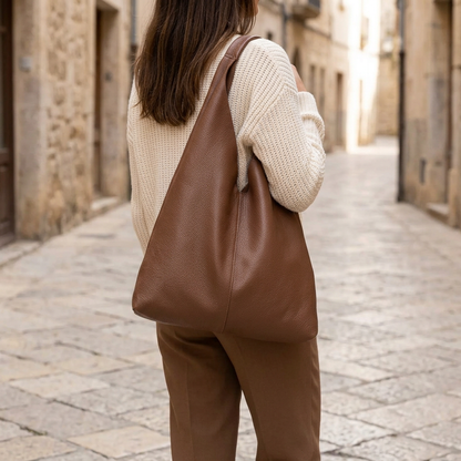 Sac shopper en cuir grainé marron porté à l’épaule par une femme vue de dos