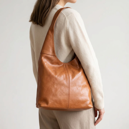 Sac à main camel porté à l’épaule par une femme vue de trois quarts arrière