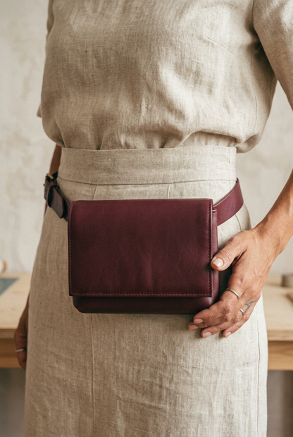 Sac Fernandita en cuir bordeaux, porté à la taille avec sa ceinture, Bmassy