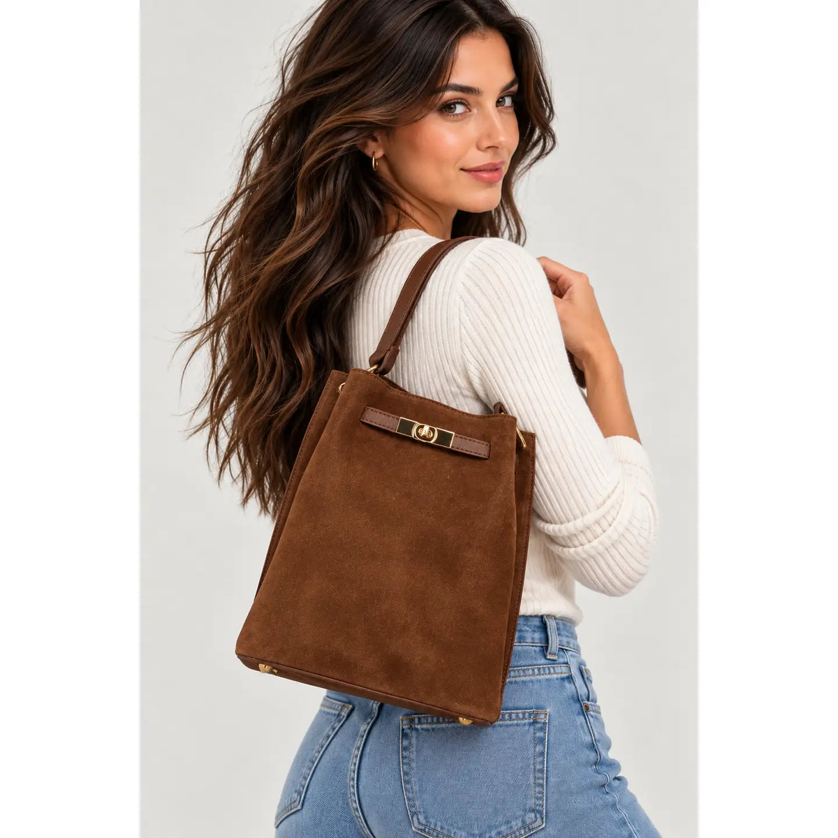 Sac rectangulaire en cuir velours marron porté à l’épaule 