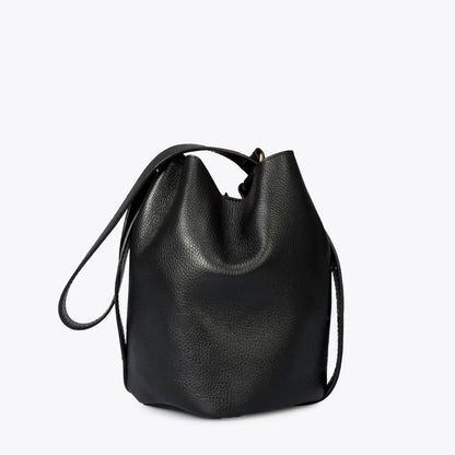 Sac seau noir vu de trois quarts, montrant son profil arrondi, son anse courte et sa bandoulière