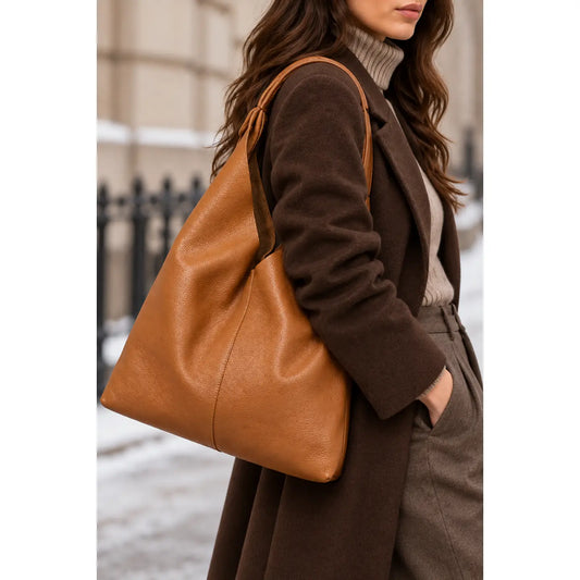 Sac shopper en cuir grainé camel porté à l’épaule par une femme vue de dos