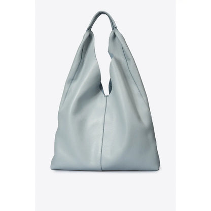 Sac shopper en cuir gris clair vu de face, le long de la jambe