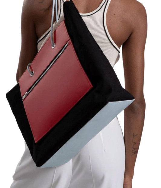 Un Sac à main noir et rouge de fourre-tout réversible et de moyenne capacité